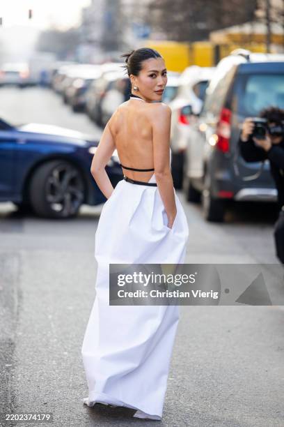 Molly Chiang wears white dress with slit, black belt outside Max Mara during the Milan Fashion Week Womenswear Fall/Winter 2025/2026 on February 27,...
