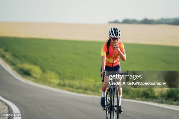 recharging with a protein bar while road cycling. - muesli bar stock pictures, royalty-free photos & images