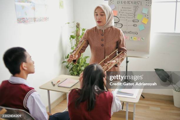 group of students with disabilities learning traditional music at the classroom - indonesian ethnicity stock pictures, royalty-free photos & images