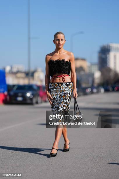 Caroline Daur wears floral layered Prada bandeau top, shiny burgundy bordeaux belted low-rise silver metallic sequin Prada midi skirt, shiny black...