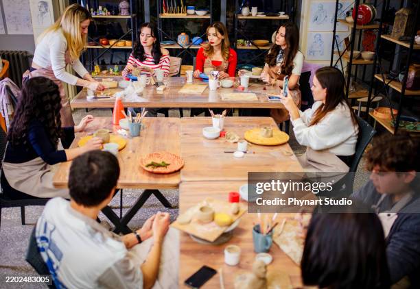 pottery workshop – instructor teaching a group of students - kunstatelier stockfoto's en -beelden