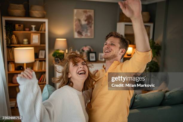 jeune couple dansant et s’amusant à la maison - flirter photos et images de collection
