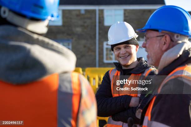 construction crew in safety gear having a discussion - construction worker stock pictures, royalty-free photos & images