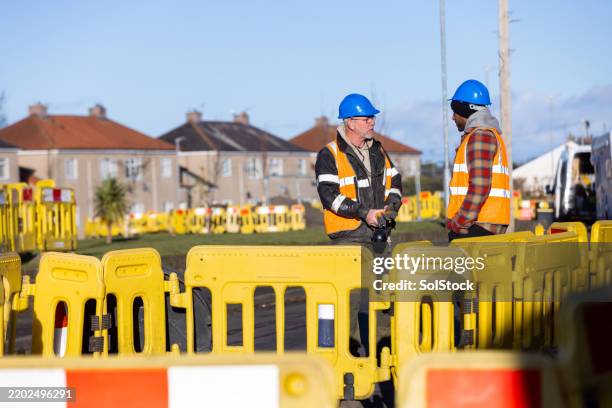 hard hat crew planning their next steps - construction barrier stock pictures, royalty-free photos & images