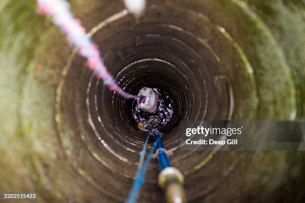 an ancient well being used to collect water near patan durbar square in kathmandu, nepal. - puits à eau photos et images de collection