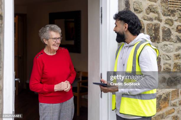 fröhliches zusammenspiel zwischen lieferfahrer und rentner - kundenwerber stock-fotos und bilder