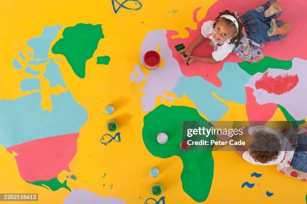 two children painting map of the world - earth painting stock pictures, royalty-free photos & images
