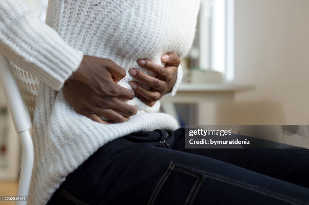 Unrecognizable female having stomachache