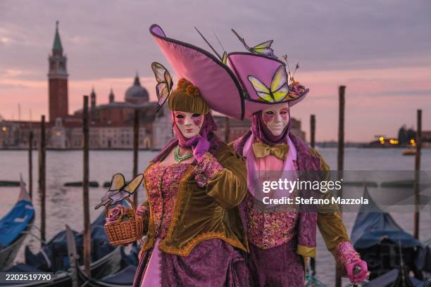 Masked revellers pose for a sunrise portrait in St. Mark's Square during the Venice Carnival 2025 on February 28, 2025 in Venice, Italy. The Venice...