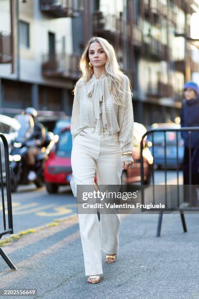 Simona Jakstaite wears gold heeled sandals, gold hoop earrings, a beige Missoni long sleeved shirt, gold bracelets, a white cream Bottega Veneta...