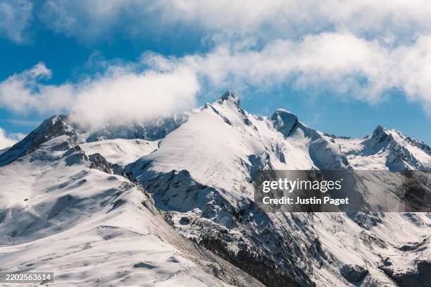 landscape view of a snowy mountain ridge above the col d'aubisque in the french pyrenees - snowcapped mountain stock pictures, royalty-free photos & images
