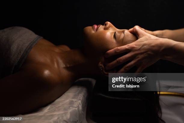 experienced massage therapist stimulating acupoint on woman face. - spa bildbanksfoton och bilder