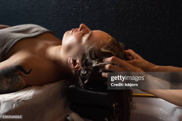 una escena tranquila de una mujer disfrutando de un tratamiento de spa para el cabello. - cuero cabelludo fotografías e imágenes de stock