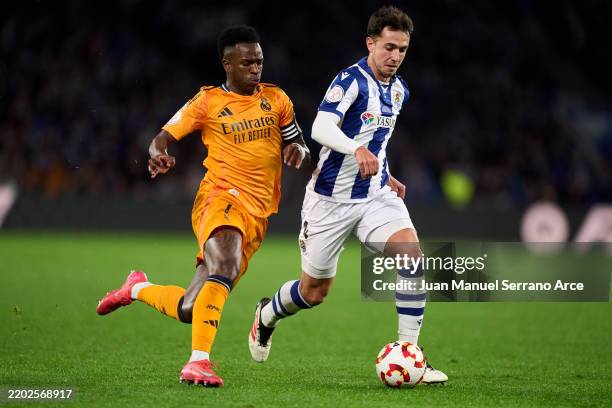 Vinicius Junior of Real Madrid duels for the ball with Martin Zubimendi of Real Sociedad during the Copa del Rey Semi Final match between Real...
