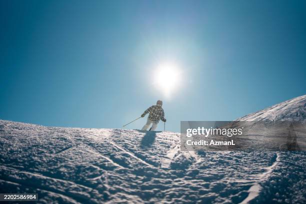 mid adult asian male skiing down snowy slope - ski pole stock pictures, royalty-free photos & images