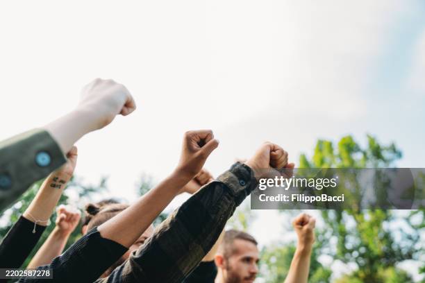 a group of activists are raising their fists - blm fist stock pictures, royalty-free photos & images