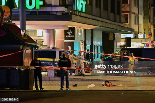 Police investigators work at the scene of car ramming attack in Mannheim, southwestern Germany on March 3, 2025. A car driven into a crowd in...