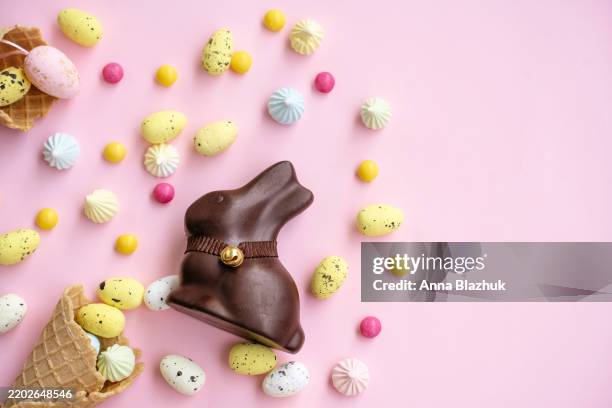 chocolate easter bunny, eggs, flowers and candies. colorful spring festive table setting for easter - broken easter egg stock pictures, royalty-free photos & images