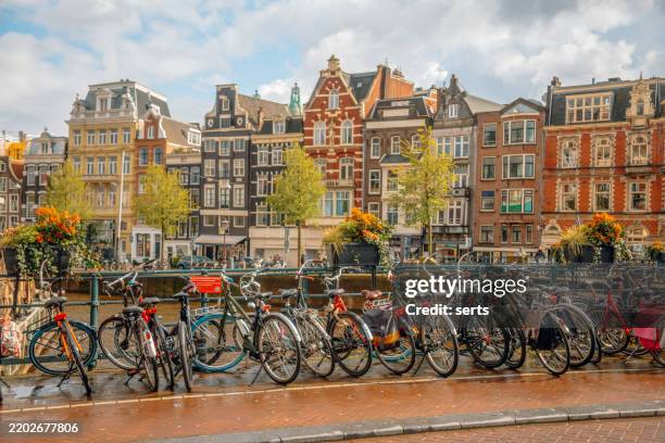 fahrräder, die an einem kanal in amsterdam, niederlande, abgestellt sind - hollandrad stock-fotos und bilder