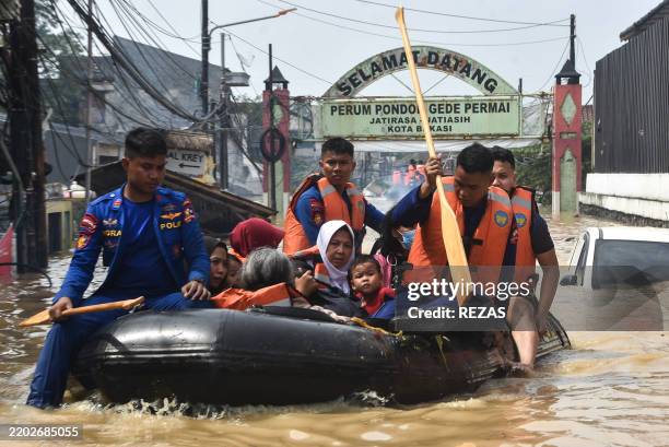 Rescue teams evacuate people whose homes have been flooded at Pondok Gede Permai Housing Complex in Bekasi, West Java on March 4, 2025.