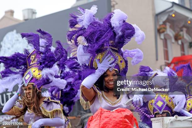 Maids riding on a float struggle to keep their headpieces in place under windy conditions as the Krewe of Zulu parade rolls up Poydras Street on...