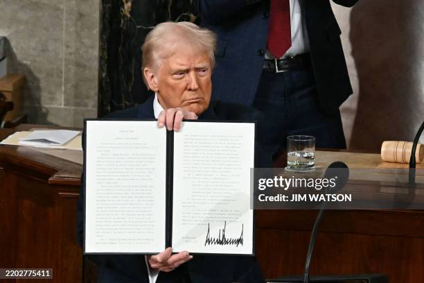President Donald Trump holds up an executive order that renames a wildlife sanctuary in honor of the late Jocelyn Nungaray, a 12 year-old girl who...