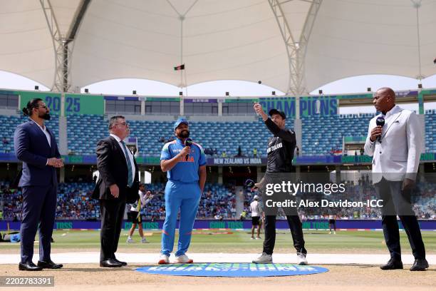 Match Referee David Boon and Rohit Sharma of India looks on as Mitchell Santner of New Zealand flips the coin at the coin toss prior to the ICC...