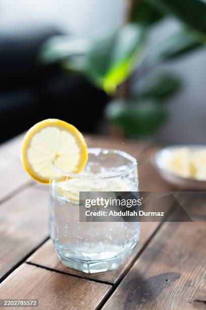 refreshing sparkling water with lemon slice on wooden table - carbonated water stock pictures, royalty-free photos & images