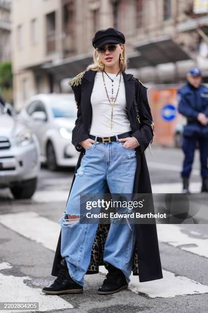 Guest wears black hat, dark sunglasses, gold earrings, gold black layered rosaries necklace, white t-shirt, black oversized embroidered blazer coat,...