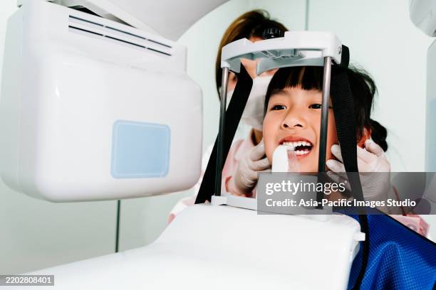gros plan d’une petite fille asiatique prenant des radiographies. - équipement de radiologie photos et images de collection