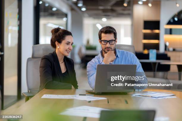 businessman presenting marketing data and work plan analysis to businesswoman executive in modern office for strategic decision-making and future business development. - continuidade imagens e fotografias de stock