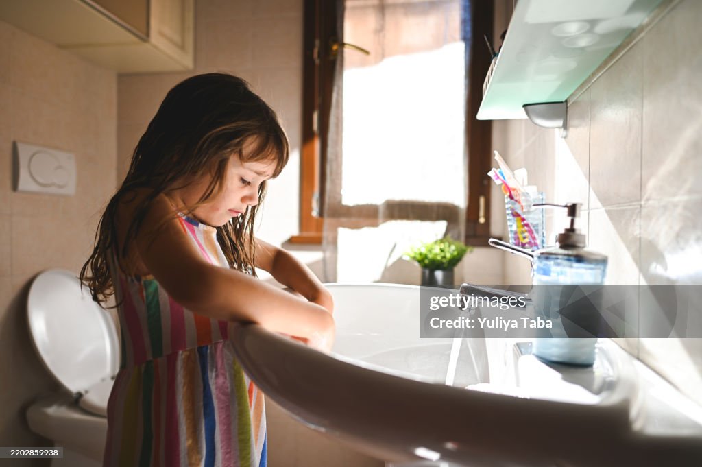 Child playing with soap in bathroom.