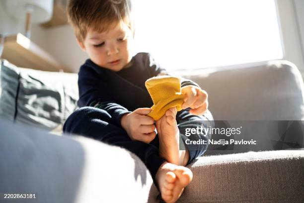 niño pequeño se pone calcetines - vestirse fotografías e imágenes de stock