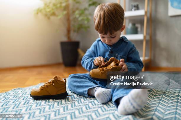 petit garçon nouant ses lacets de chaussures - attacher photos et images de collection