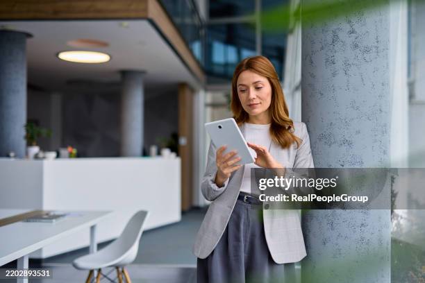 businesswoman using digital tablet in modern office - using digital tablet stock pictures, royalty-free photos & images