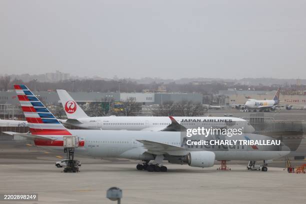 An Airbus A350 passenger aircraft of Japan Airlines and Boeing 777 passenger aircraft of American Airlines are pictured as a Boeing 747 cargo...