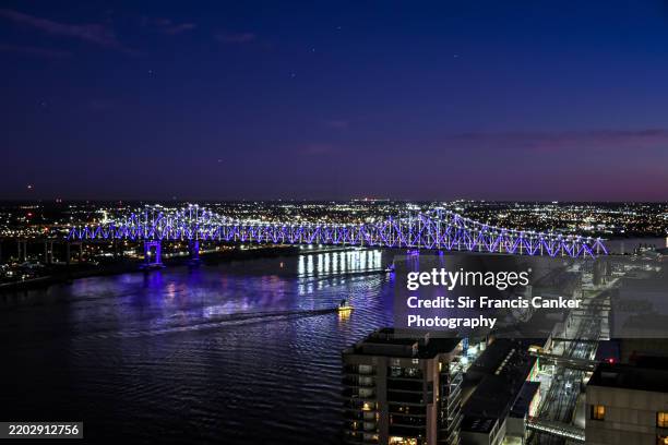 "crescent city connection" bridge in new orleans ("nola") illuminated at dusk over mississippi river in new orleans, louisiana, usa - great new orleans bridge stock pictures, royalty-free photos & images
