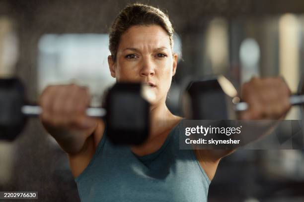 determined athletic woman exercising with weights in a gym. - tyngdlyftning bildbanksfoton och bilder