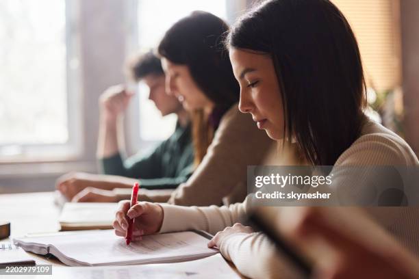 female college student learning on a class at classroom. - middelbare scholier stockfoto's en -beelden