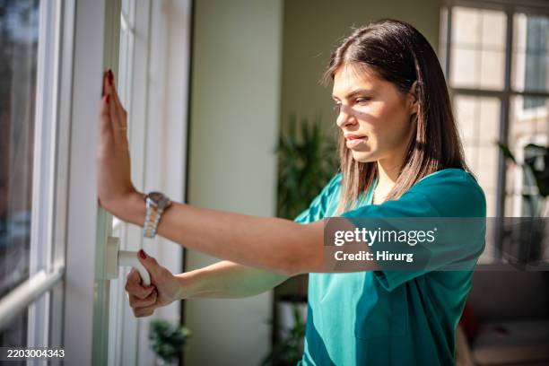 une jeune infirmière portant une blouse effectue un travail concentré à l’intérieur d’un hôpital - fermé photos et images de collection