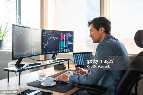 asiatischer finanzhändler, der marktdaten auf mehreren bildschirmen analysiert - börsenhandel finanzberuf stock-fotos und bilder