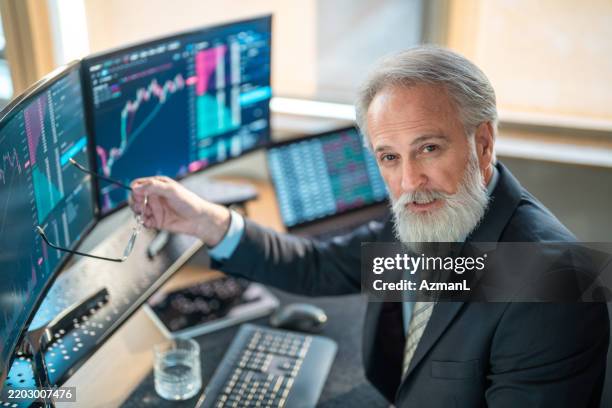mature male stock broker in modern office setting - werkende bejaarden stockfoto's en -beelden