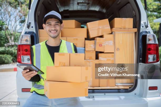 male delivery stands using tablet to check address of package before delivering to customer. - orthographic symbol stock pictures, royalty-free photos & images