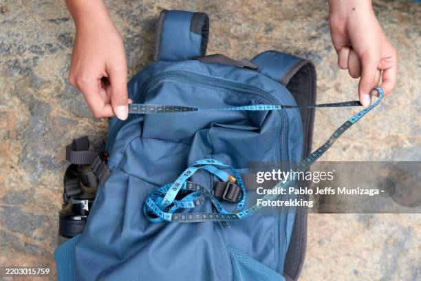 traveler measuring backpack size with tape measure for airline baggage allowance - flugpassagier stock-fotos und bilder