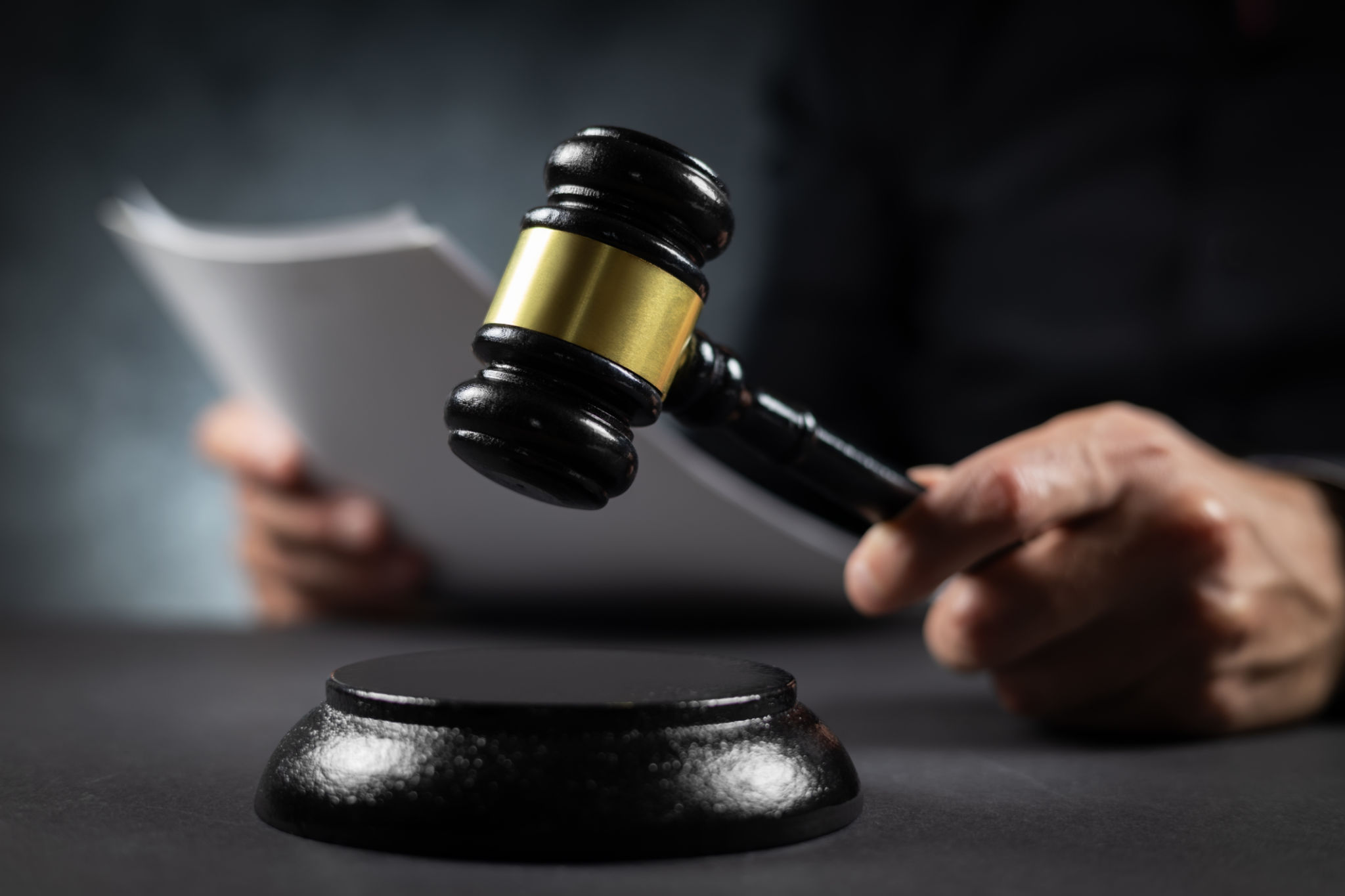 Judge with paper document pronouncing sentence in a court of law. Judge with paper document pronouncing sentence in a court of law.