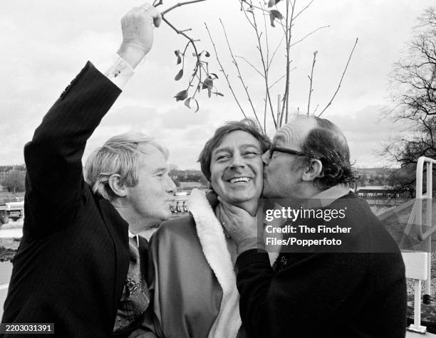 English entertainrs and friends, left to right: comedian Ernie Wise , singer Des O'Connor and comedian Eric Morecambe with a sprig of mistletoe,...