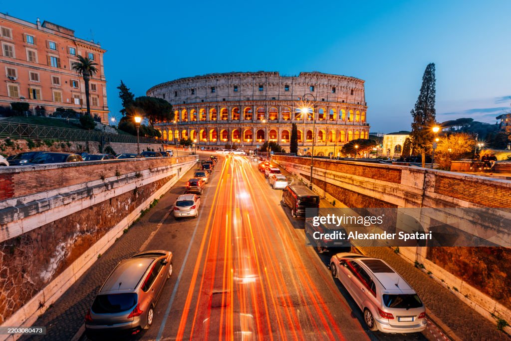 Coliseum and Rome skyline illuminated at dusk, elevated view, Lazio, Italy