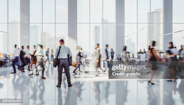 businessman standing in crowds of people - brightly lit stock pictures, royalty-free photos & images