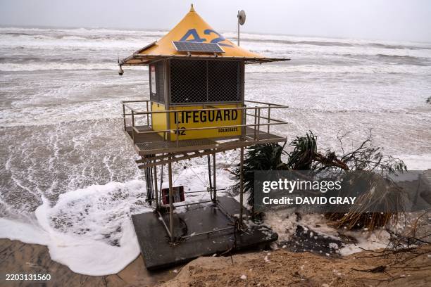 Lifeguard tower is surrounded by water on Main Beach that has been damaged by record-breaking waves caused by the outer fringe of Tropical Cyclone...