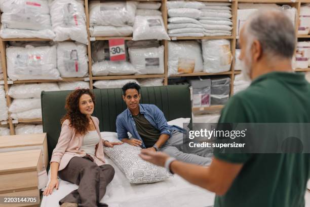 relaxing on a mattress in cozy bedding store - matras stockfoto's en -beelden